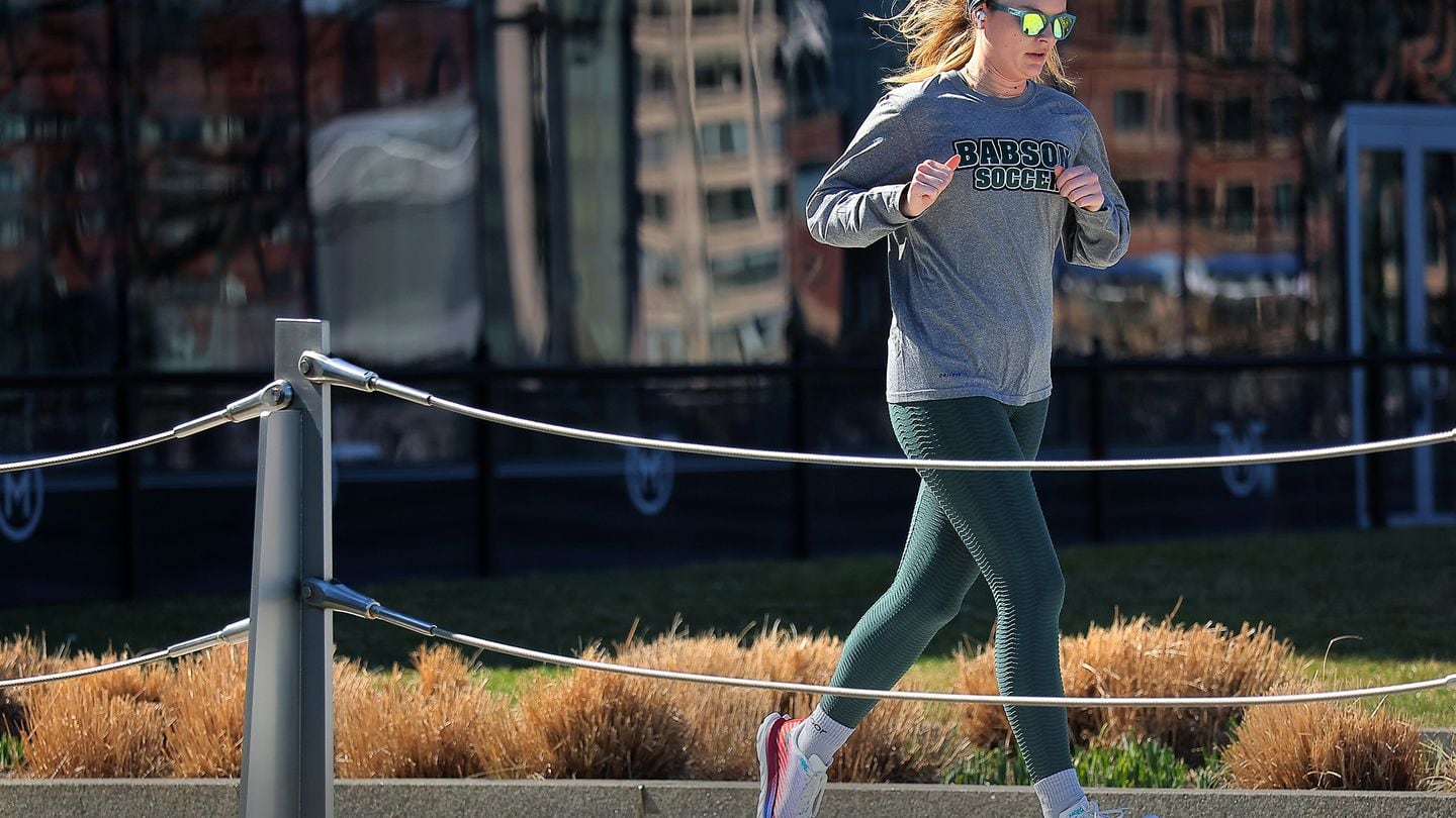 A runner enjoyed the Harborwalk on a warm, sunny day in the Seaport District on Thursday.