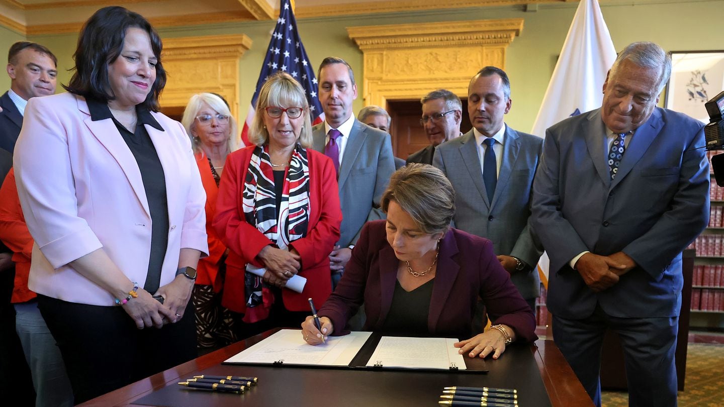 Governor Maura Healey signs a $1 billion tax overhaul bill into law at the Massachusetts State House Library.